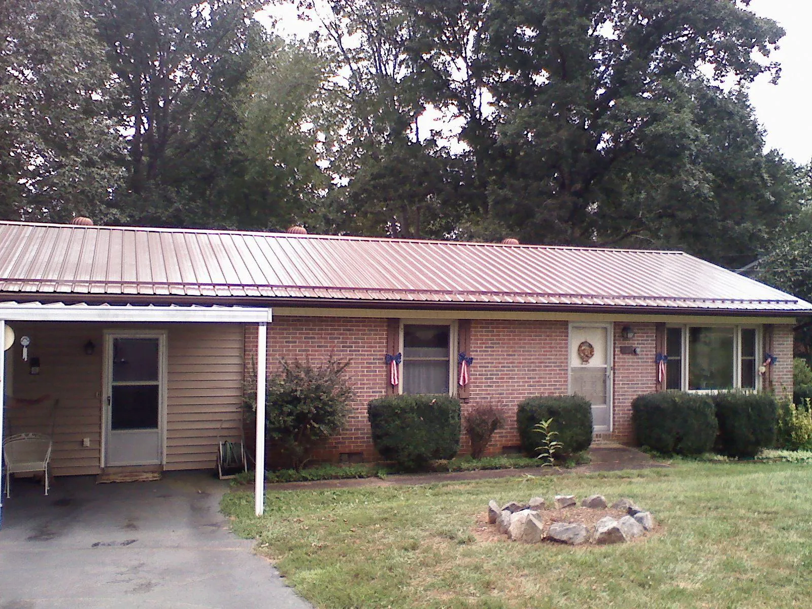 Bronze metal roof and carport on a brick ranch home — Roof Repair work by our crew in Sheridan